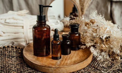 Modern still life with amber glass bottles on a wooden tray, evoking a serene, natural atmosphere.